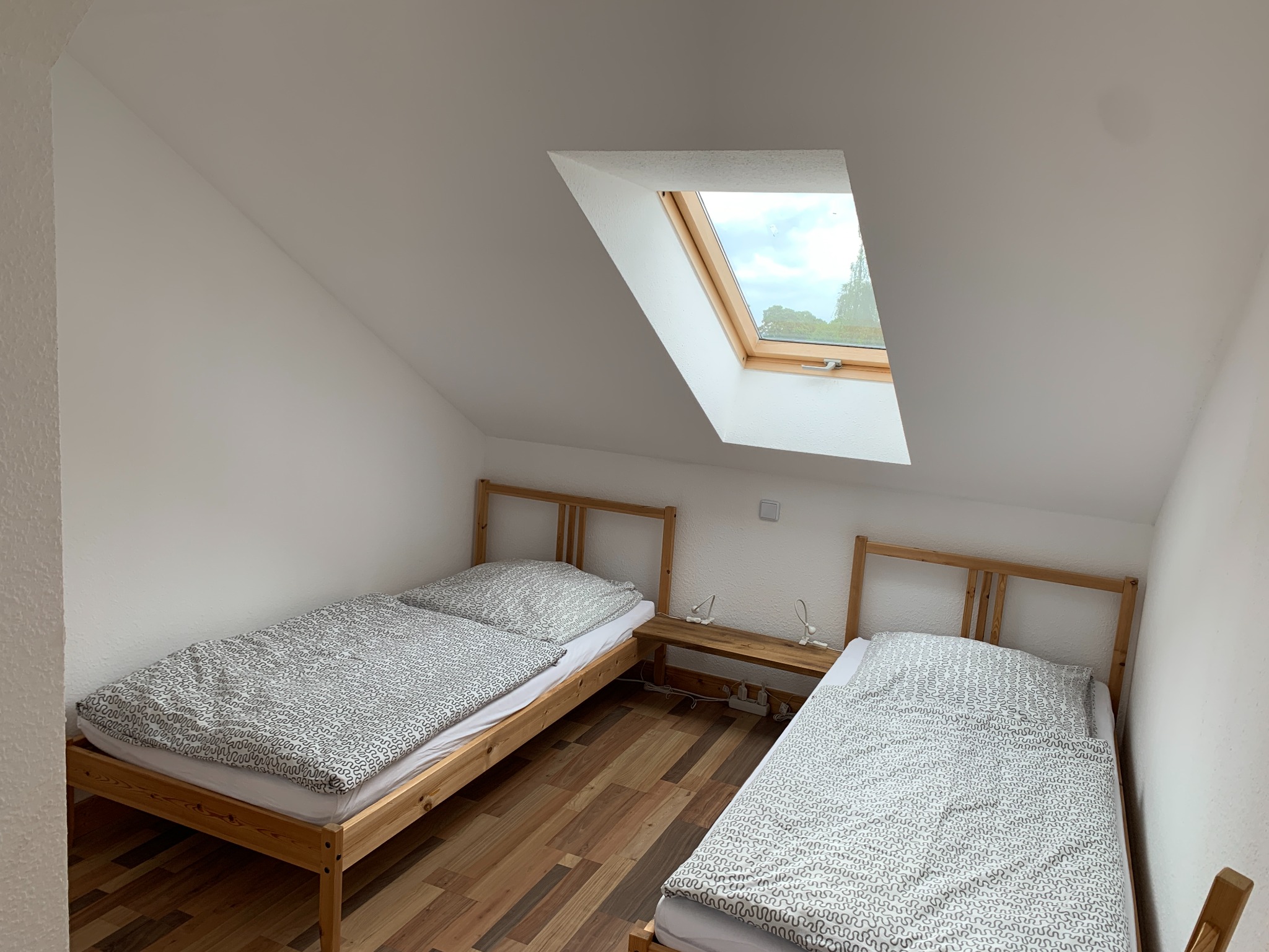 Basic triple room with two single beds under a skylight